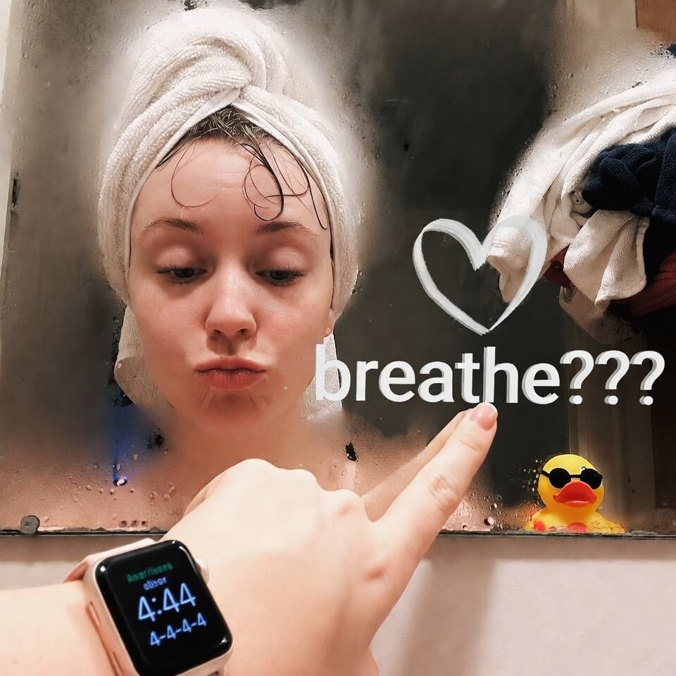 Towel-wrapped person in steamy bathroom mirror, finger-drawn "breathe???" heart