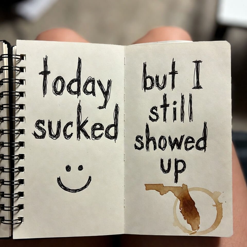Open notebook with shaky "today sucked" and defiant "but I still showed up"
